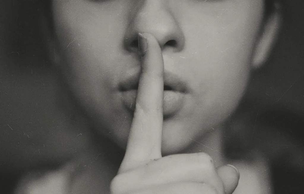 a woman with her finger up to her mouth to indicate quiet